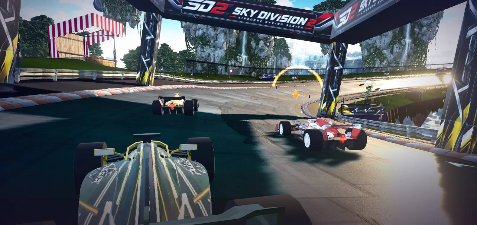 Four open-wheel cars racing around a suspended circuit beneath the Sky Division 2 gantry